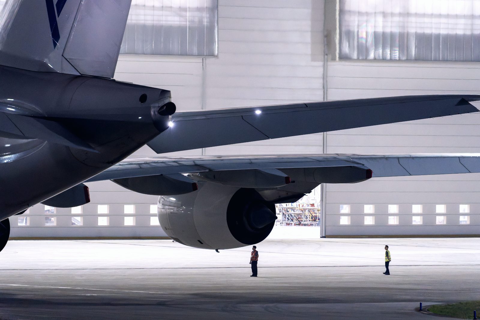 Technicians under the wing in the hangar